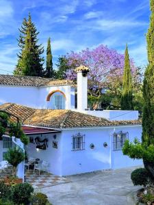 a white house with a patio and trees at Finca Villordo Villa Tranquila in Benalmádena