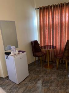 Bamod Hotel and Suites في ليكى: غرفة بطاولة وكرسيين ونافذة