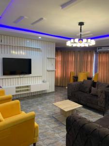 ein Wohnzimmer mit Sofas und einem Flachbild-TV in der Unterkunft Bamod Hotel and Suites in Lekki