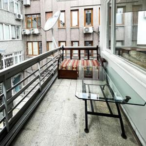 uma varanda com uma cama e uma mesa de vidro em Huge Cozy 5+1 Flat em Istambul