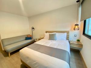 um quarto com uma cama grande e um sofá em Darwin 8 em Cidade do México
