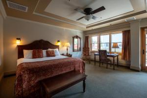 a hotel room with a bed and a desk and window at Kaslo Hotel in Kaslo