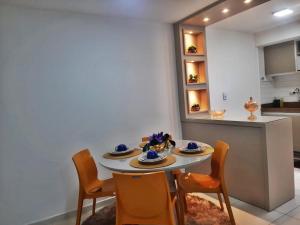 uma sala de jantar com mesa e cadeiras e uma cozinha em Atlântico Tambaú Home Service em João Pessoa