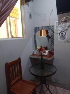 una mesa con un jarrón de flores y una silla en San Diego Tu Casa, en Campeche