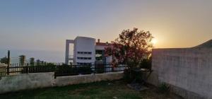 a building with a fence in front of the ocean at Apartman Haris in Dobra Voda