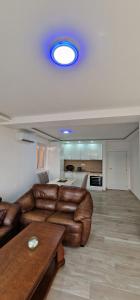 a living room with a leather couch and a table at Apartman Haris in Dobra Voda +7 photos