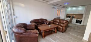 a living room with two leather chairs and a table at Apartman Haris in Dobra Voda