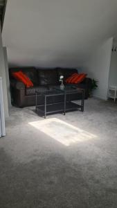 a living room with a black couch and a table at Cosey 1 bedroom loft with free parking in Stavanger