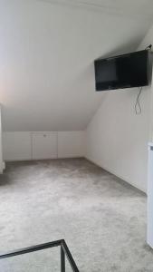 pusty pokój z telewizorem z płaskim ekranem na ścianie w obiekcie Cosey 1 bedroom loft with free parking w Stavangerze