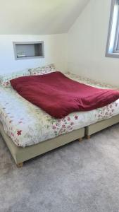 a bed with a red blanket on top of it at Cosey 1 bedroom loft with free parking in Stavanger