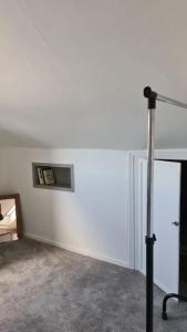 a room with a white wall and a tripod at Cosey 1 bedroom loft with free parking in Stavanger