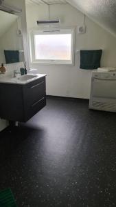 a bathroom with a sink and a window at Cosey 1 bedroom loft with free parking in Stavanger