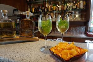 two glasses of wine and chips and bottles of alcohol at Hotel Riviera in Riva del Garda