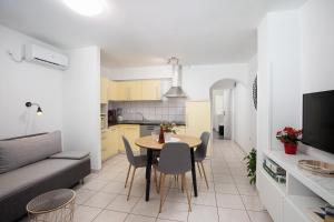 een woonkamer en een keuken met een tafel en stoelen bij Apartments with a parking space Valbandon, Fazana - 7227 in Fažana