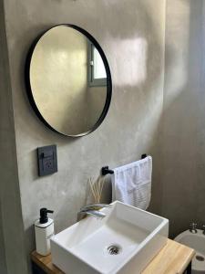 uma casa de banho com um lavatório branco e um espelho. em Exclusive Urban Apartment em Mendoza
