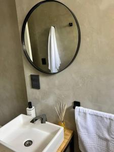 uma casa de banho com um lavatório branco e um espelho. em Exclusive Urban Apartment em Mendoza