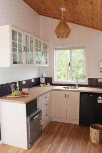 a kitchen with white cabinets and a wooden ceiling at Little Sherwood Drouin Petting Zoo & Cottages in Drouin West
