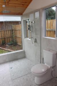 a bathroom with a toilet and a glass shower at Little Sherwood Drouin Petting Zoo & Cottages in Drouin West