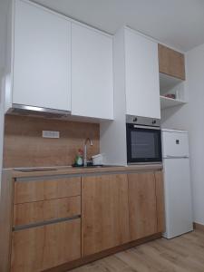 a kitchen with wooden cabinets and a refrigerator at Apartment Banjol 4965b in Rab +16 photos
