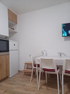 a kitchen with a table and chairs and a television at Apartment Banjol 4965b in Rab
