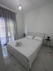 a bedroom with a large bed with two towels on it at ἕαR Exceptional Residence in Nea Peramos