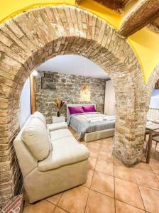 een woonkamer met een bank en een bakstenen muur bij [Centro Storico] La casa di Pietra in Perugia