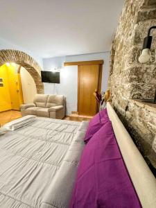 een groot bed in een kamer met een stenen muur bij [Centro Storico] La casa di Pietra in Perugia
