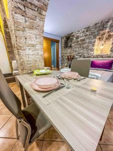 a dining table with plates and glasses on it at [Centro Storico] La casa di Pietra in Perugia