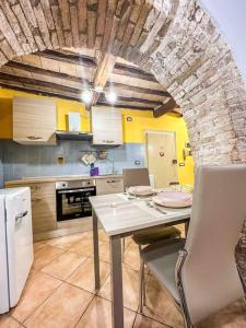 a kitchen with a table and a brick wall at [Centro Storico] La casa di Pietra in Perugia