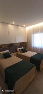 Un dormitorio con dos camas y una ventana. en Lagos Beach Apartment, en Lagos