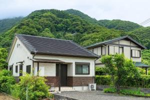 una casa con una montaña en el fondo en Seaside Villa Nagi, en Maizuru