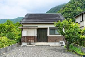 ein kleines Haus mit einer Garage und einem Berg in der Unterkunft Seaside Villa Nagi in Maizuru