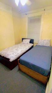 twee bedden in een kamer met bij Home stay Rooms in Slough