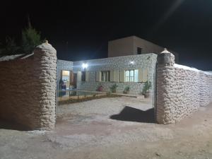 una casa con un muro di pietra di notte di Villa ahlam a Essaouira