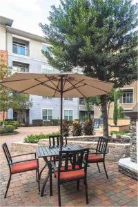 a table and chairs with an umbrella on a patio at Texan Blues in Houston