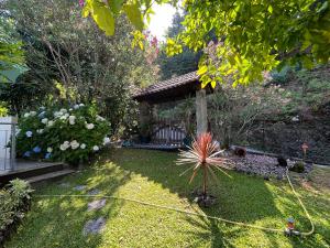 a garden with a gazebo in the background at Casa de Casarelhos - Andar da Moradia com terraço - Vistas rio - "Gerês" in Geres