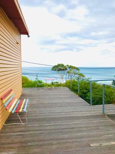 a wooden deck with a bench and the ocean at Otway Blue in Wye River
