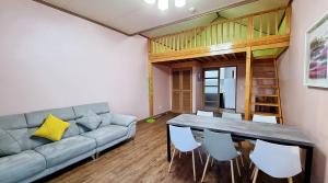 a living room with a couch and a table and chairs at Suncheon Bay Ecology Pension in Suncheon