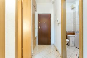 uma casa de banho com uma porta castanha e um WC. em Apartments with a parking space Kastel Stari, Kastela - 17964 em Kaštela