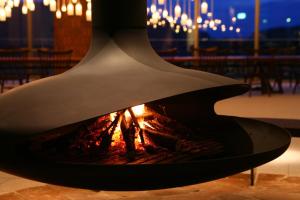 a fire pit in a room with chandeliers at Furano Hotel in Furano