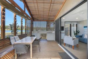 a deck with a table and chairs and a kitchen at Reflections Evans Head - Holiday Park in Evans Head