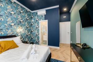 a bedroom with a bed with blue floral wallpaper at Suri Suites in Rome