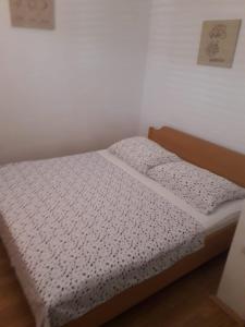a bed in a room with a white bedspread at Apartments with a parking space Sutivan, Brac - 5654 in Sutivan