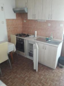 a kitchen with white cabinets and a stove and a sink at Apartments with a parking space Sutivan, Brac - 5654 in Sutivan