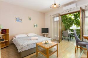 Schlafzimmer mit einem Bett, einem Tisch und einem TV in der Unterkunft Apartments with a parking space Kastel Stafilic, Kastela - 20802 in Kaštela