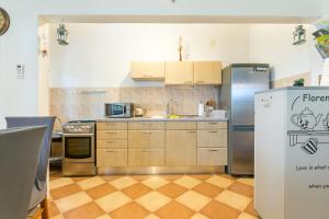 eine Küche mit Holzschränken und einem Kühlschrank in der Unterkunft Apartments with a parking space Kastel Stafilic, Kastela - 20802 in Kaštela