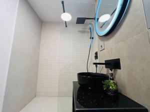 uma casa de banho com um lavatório preto e um espelho em Impact Apartments em Piteşti