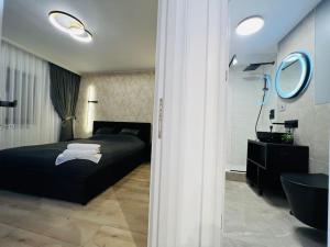 a bedroom with a black bed and a mirror at Impact Apartments in Piteşti