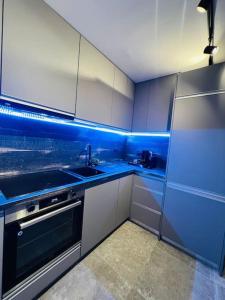 uma cozinha azul com um lavatório e uma máquina de lavar louça em Impact Apartments em Piteşti