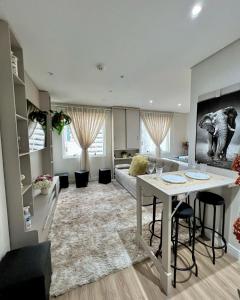 sala de estar amplia con mesa y sofá en 904 - Flat Studio Consolação Premium Elegance, en São Paulo